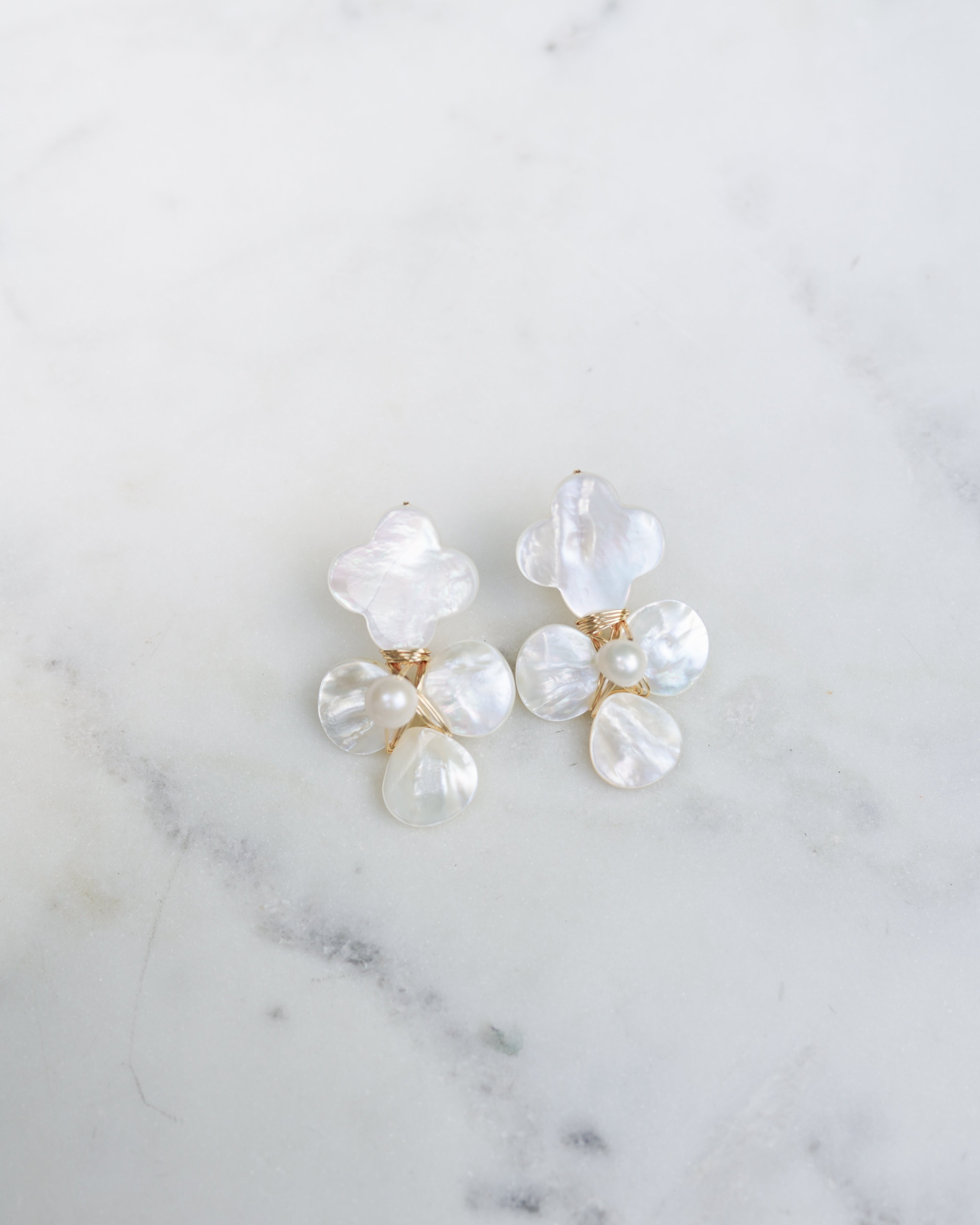 Pearl earrings on a marble surface