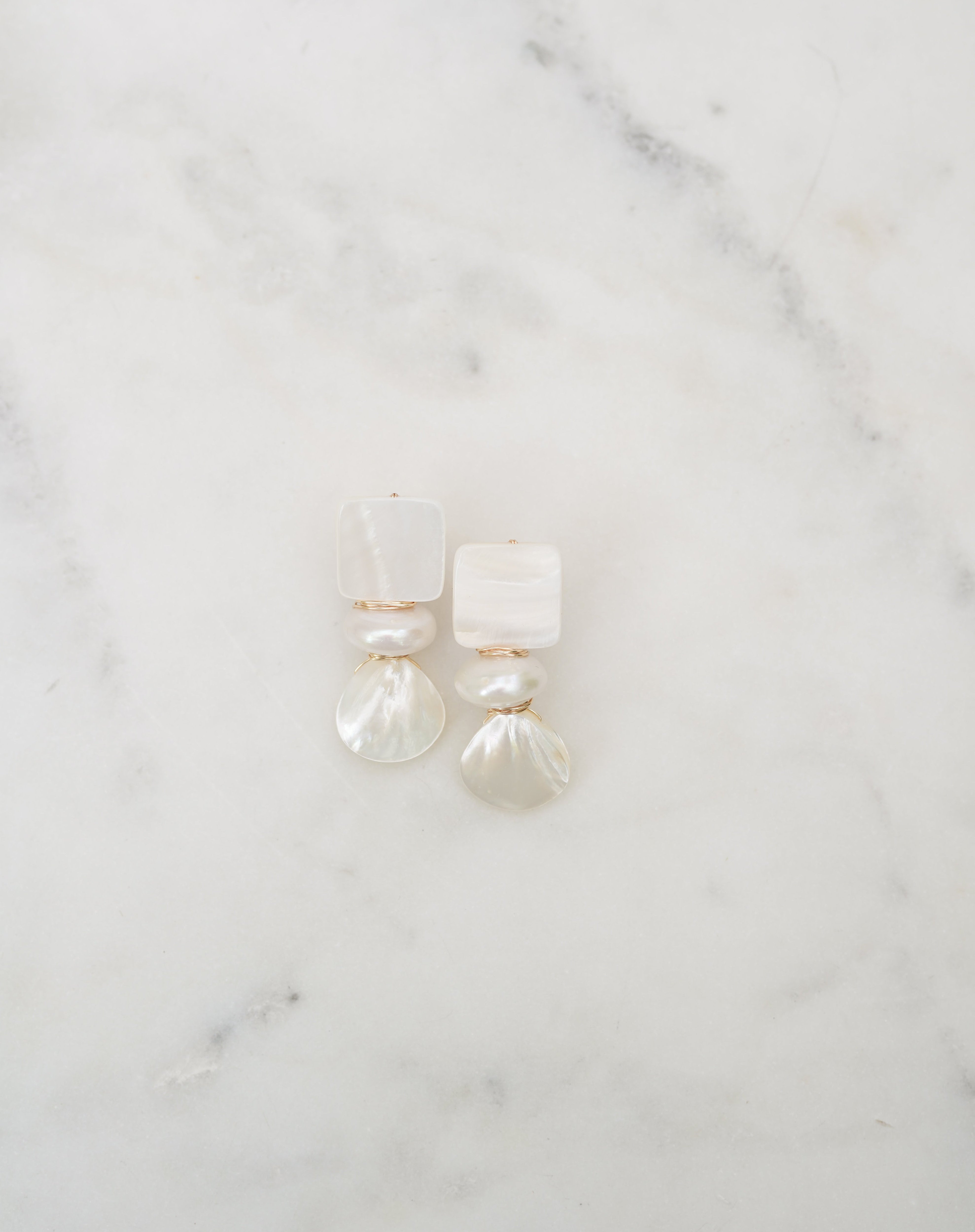 Pearl earrings on a marble surface
