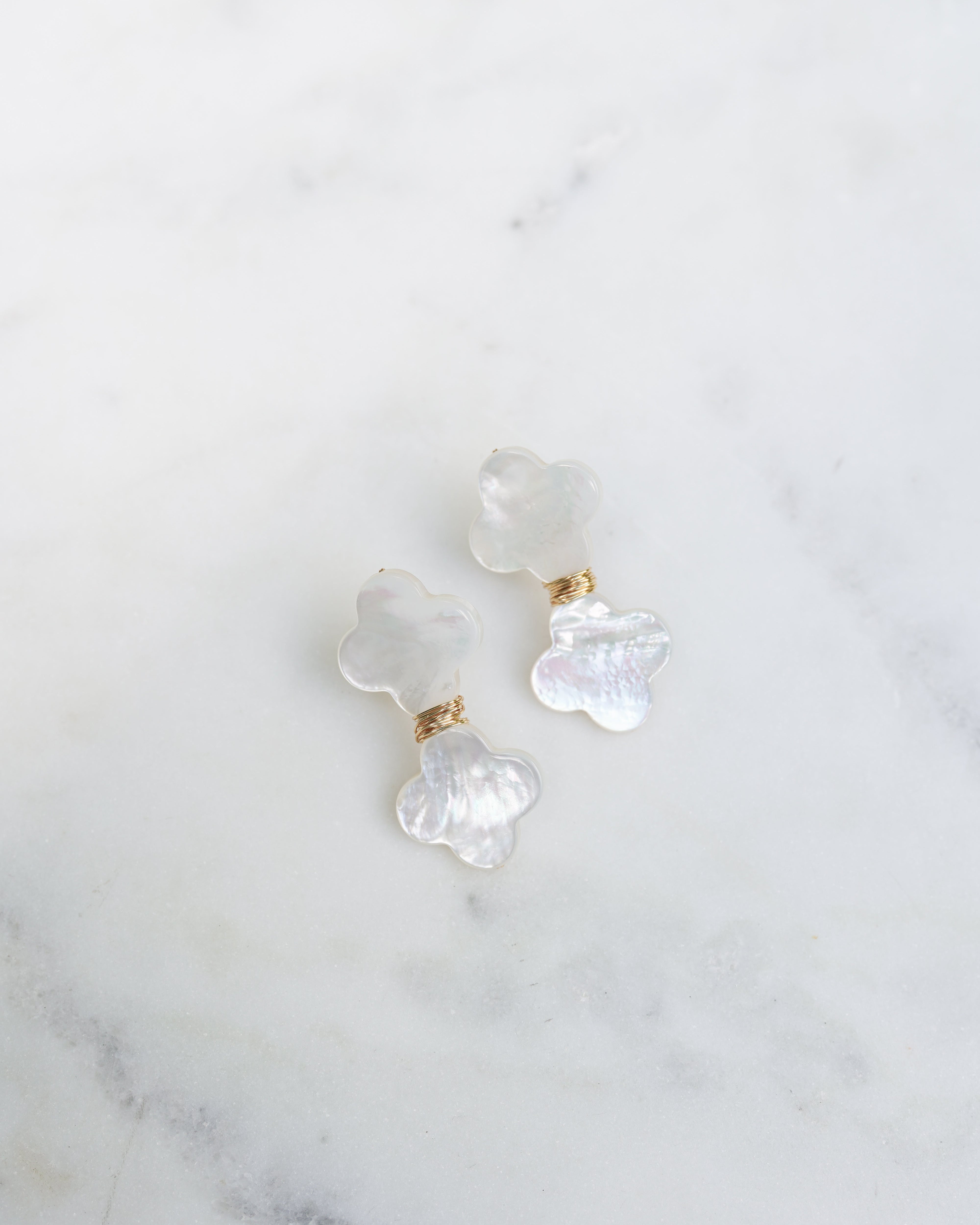 Pair of pearl earrings on a marble surface