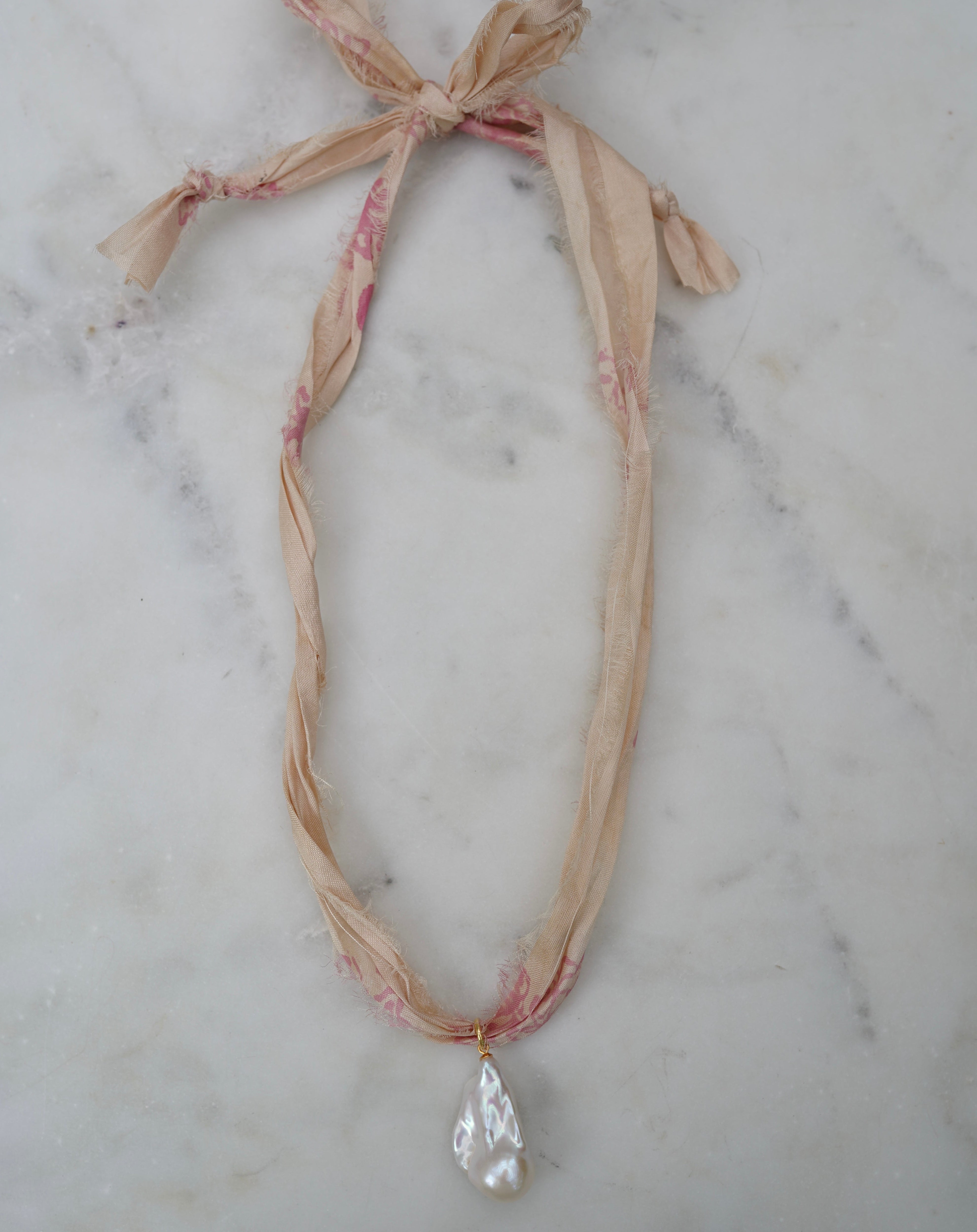 Necklace with a pendant on a marble surface