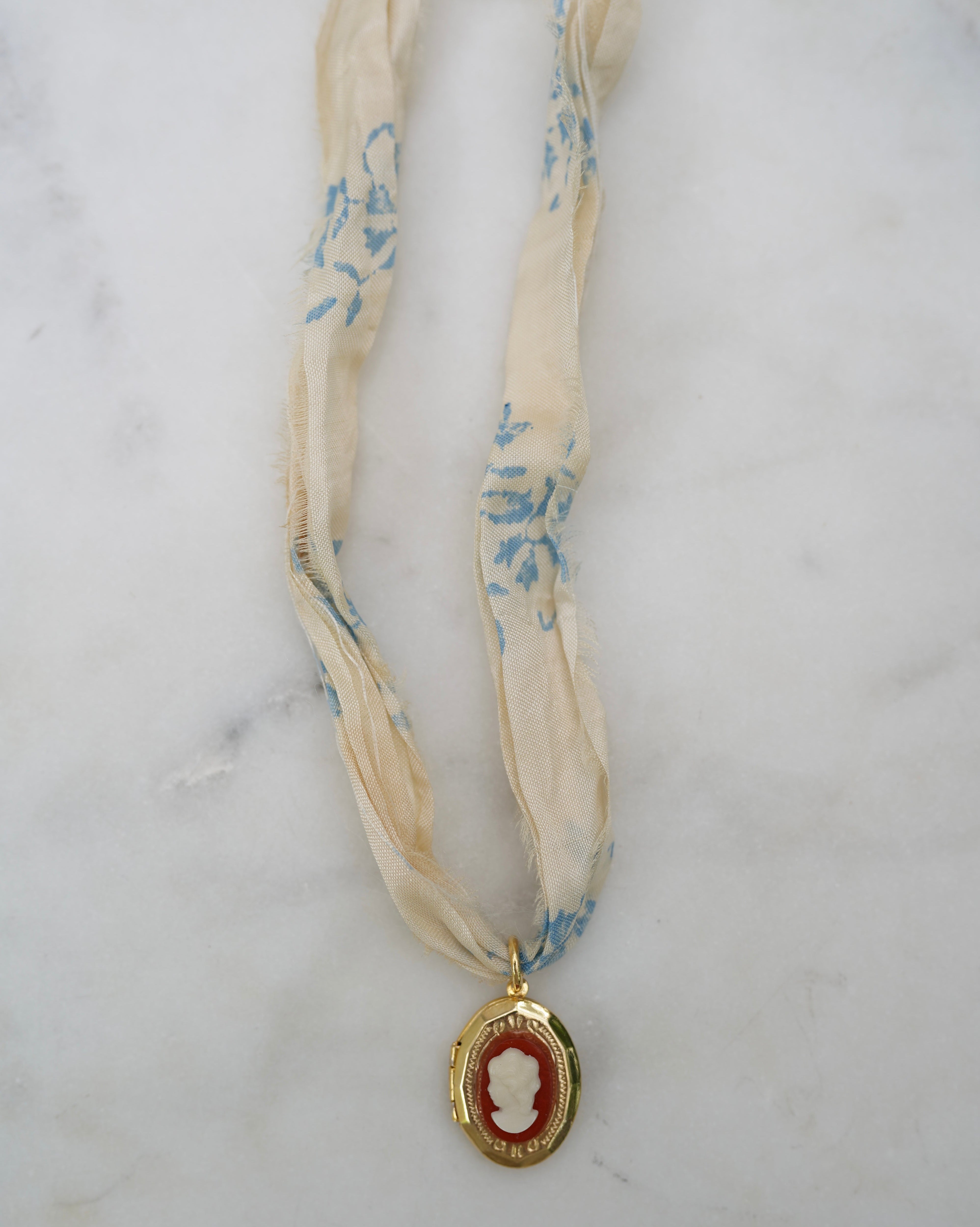 Ribbon necklace with cameo design on a marble surface