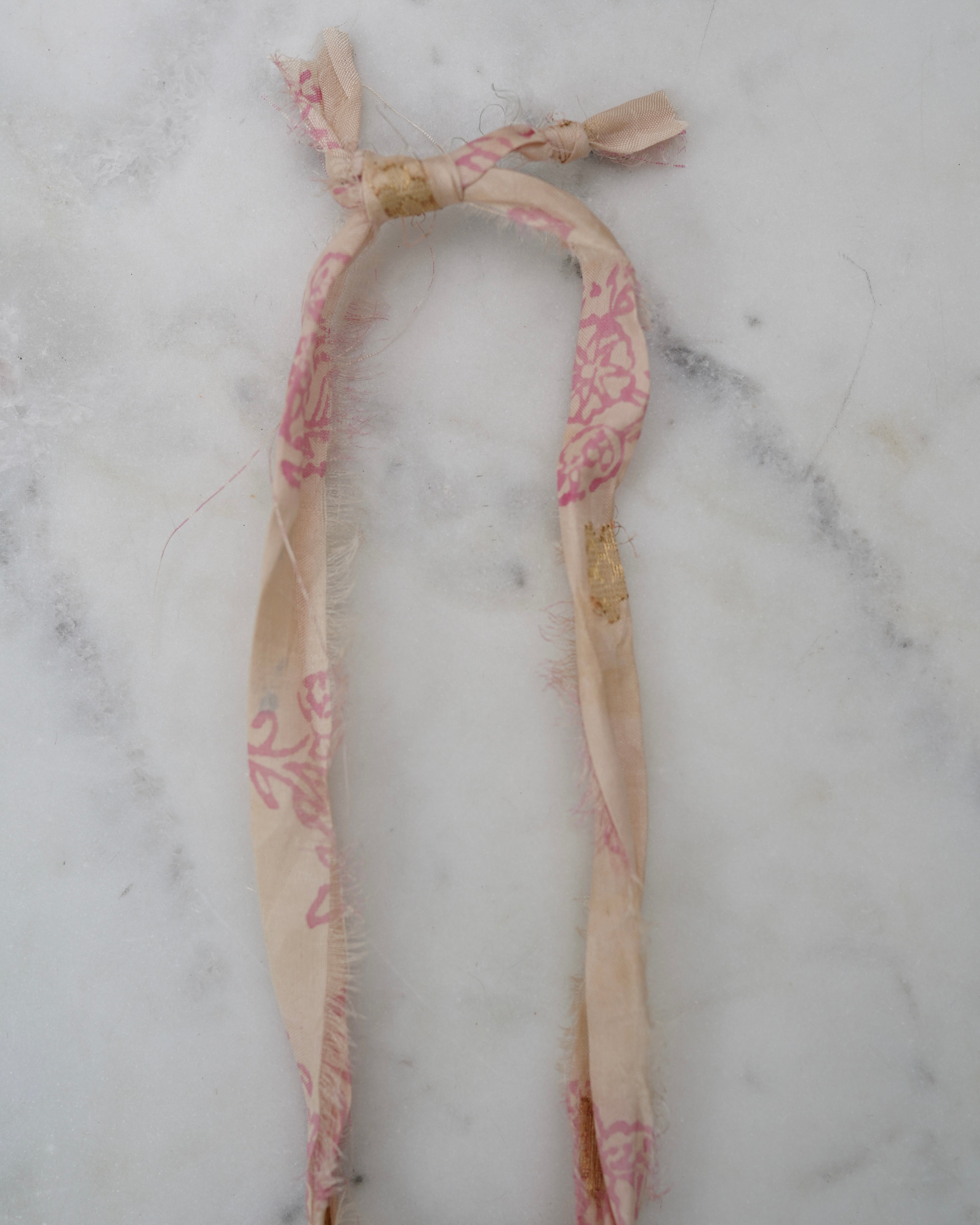 Necklace with pink floral pattern on a marble surface
