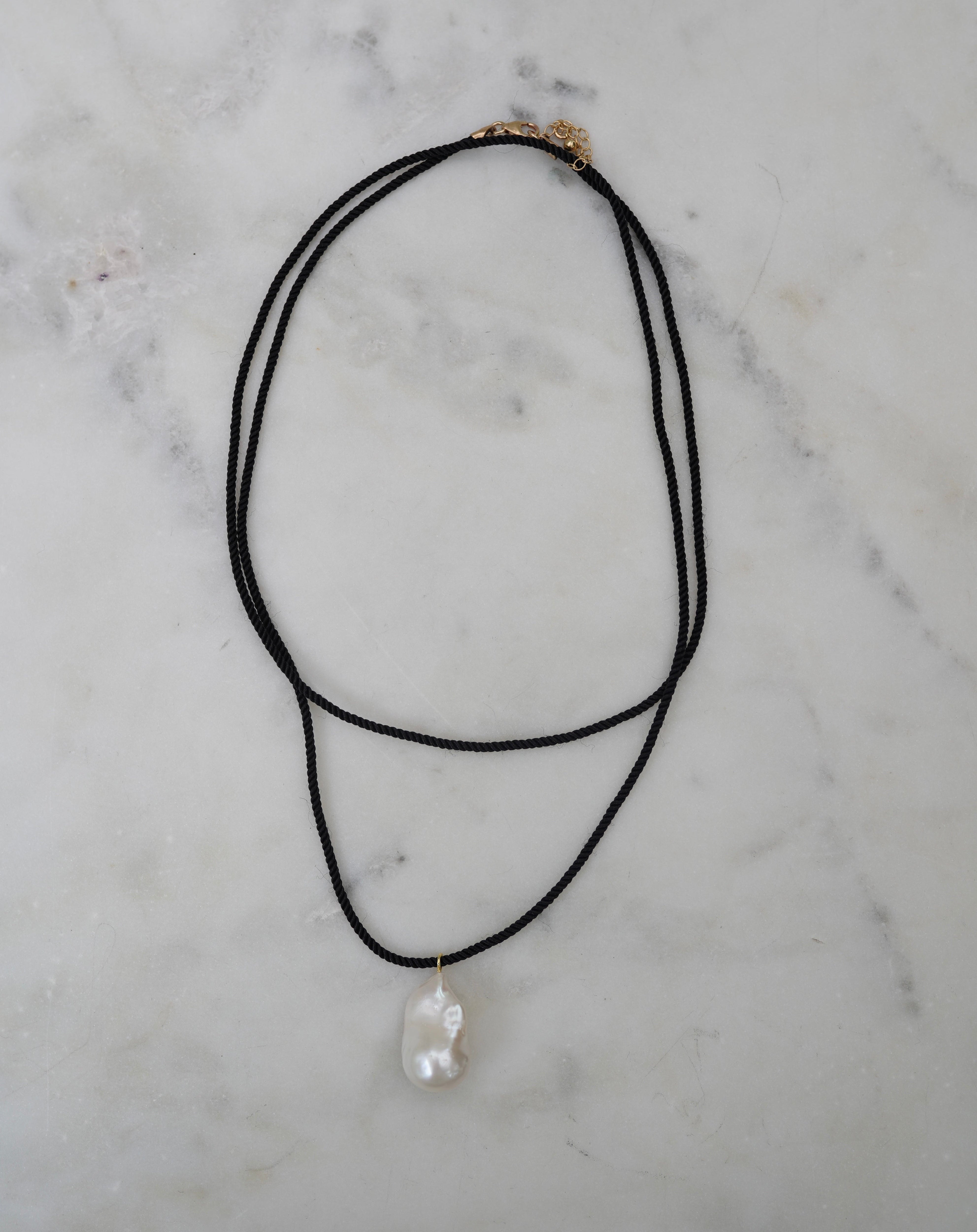 Necklace with a pendant on a marble surface